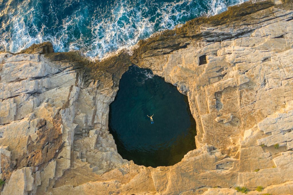 Aerial drone view of a woman swimming Giola lagoon