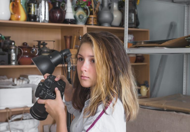 Beautiful teenage girl learns the basics of photography in an art class