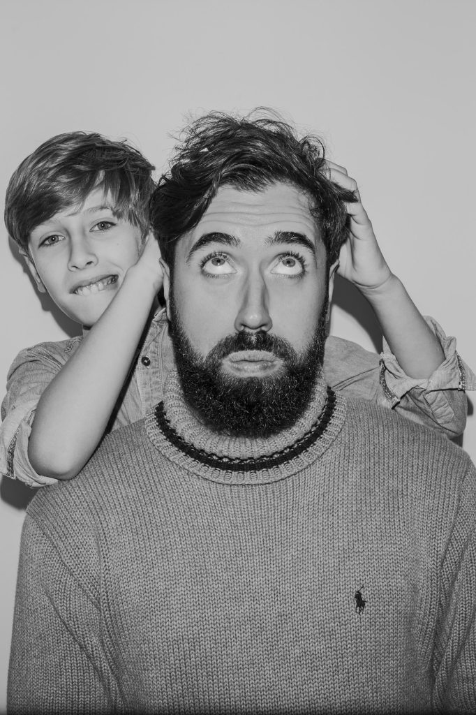 Black and white portrait of a father and son joking.