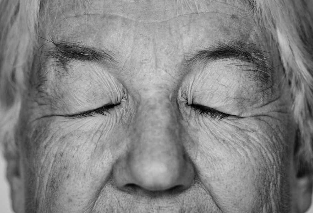 Black and white portrait of a white elderly woman eyes closed