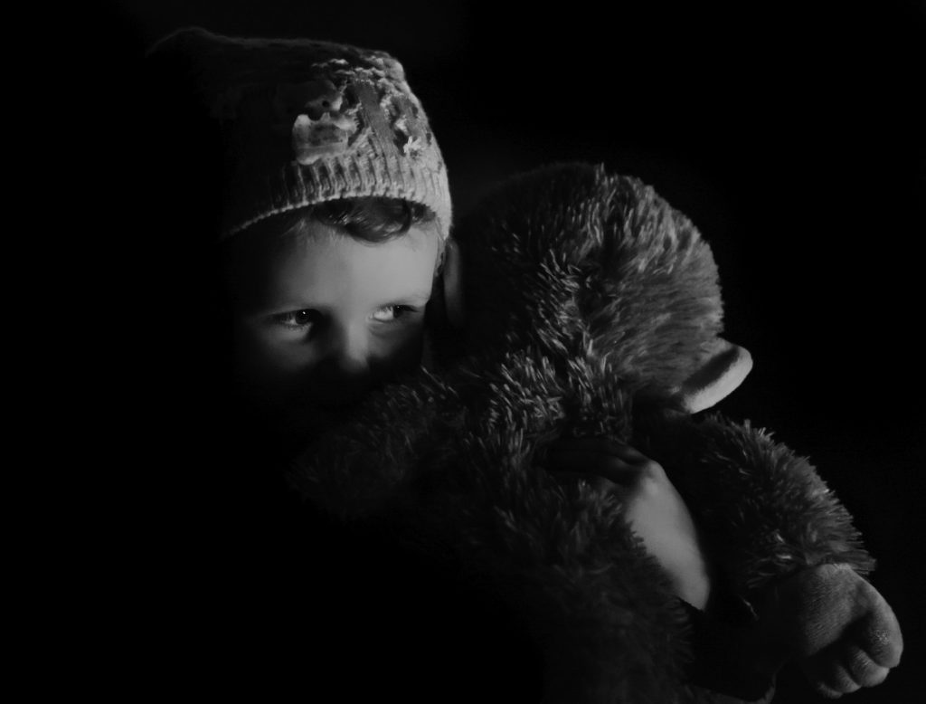 Child with favorite toy in the dark.