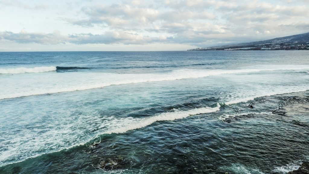 clean blue ocean water with waves and foam. top view from dron - aerial photography