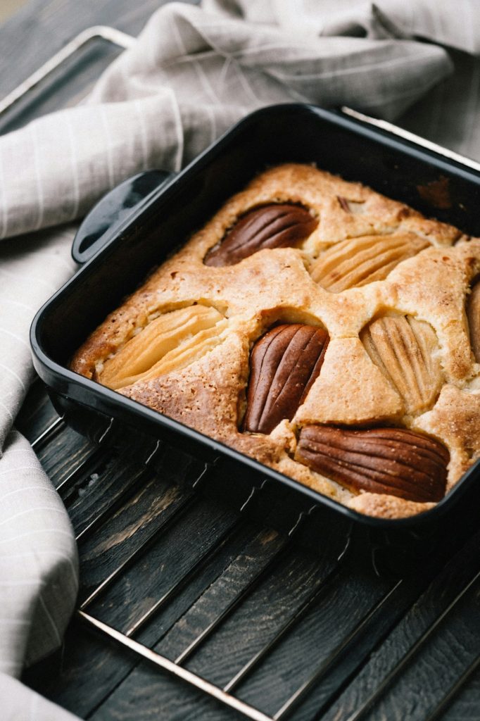 Fall pear cake in black ceramic bakeware. Food photography concept