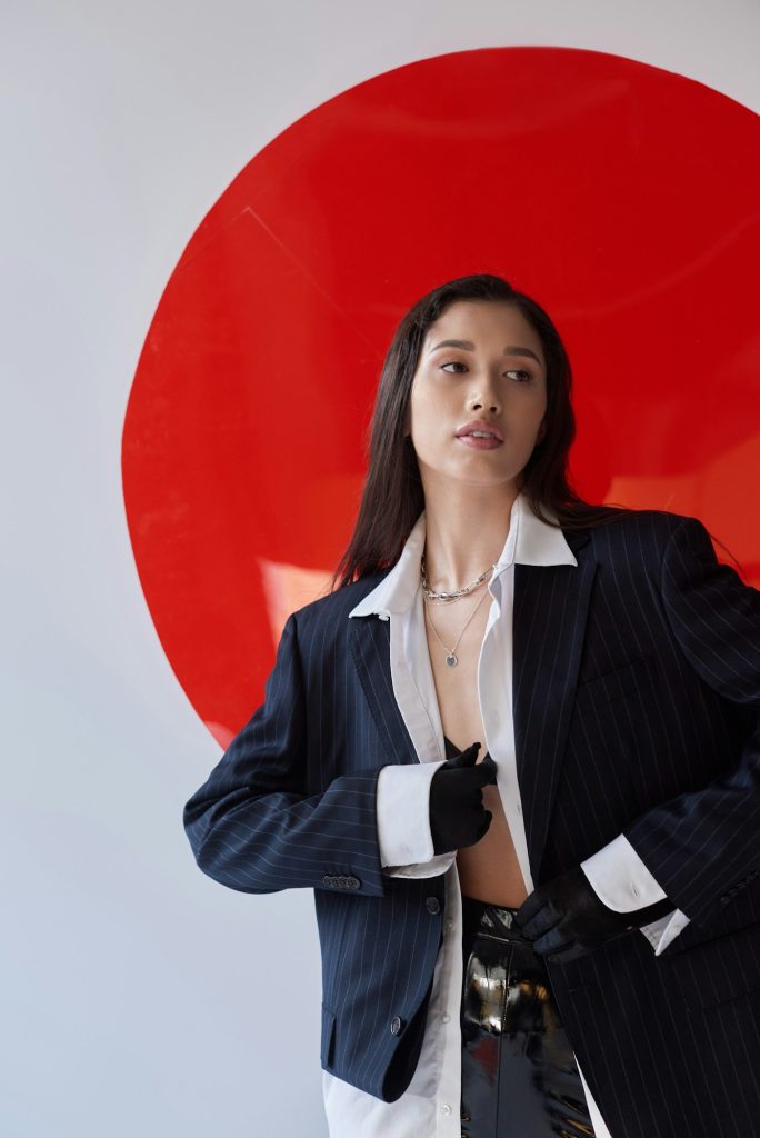 fashion photography, young asian model in white shirt and blazer posing in gloves and latex shorts