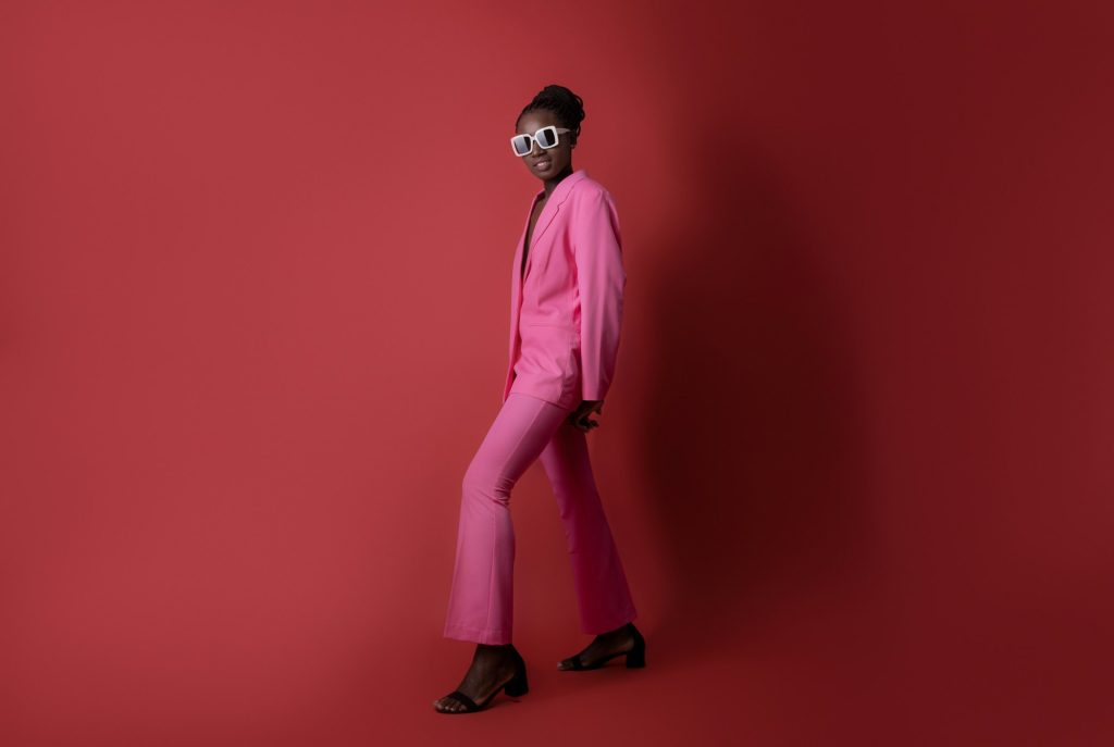 Fashion Shot Of Stylish Black Female Model Wearing Pink Suit And Sunglasses