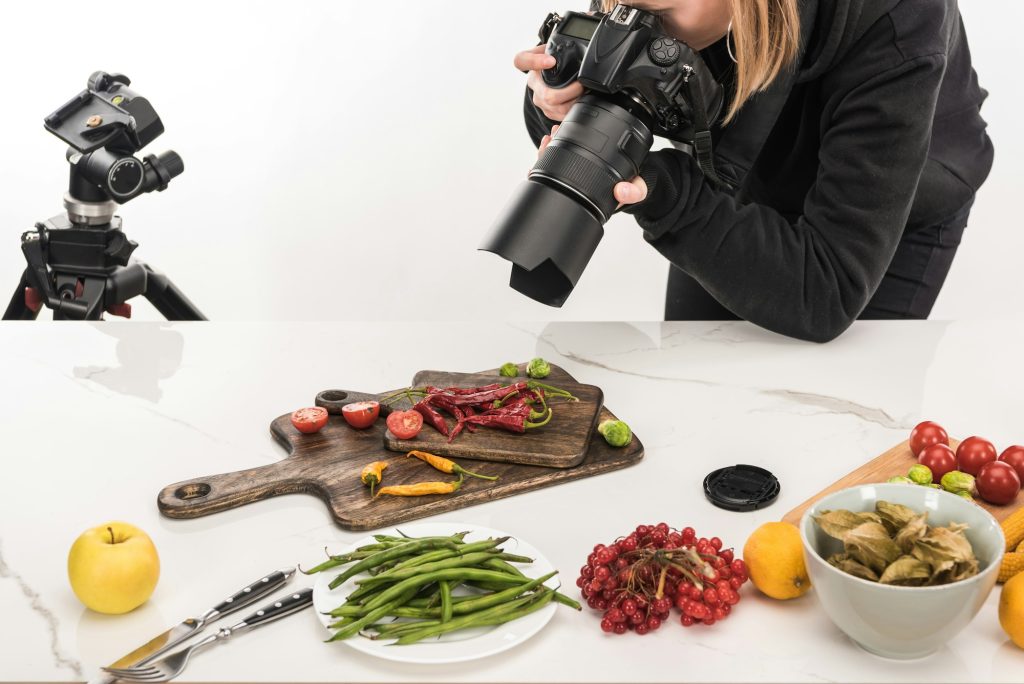 female photographer making food composition for commercial photography and taking photo on digital