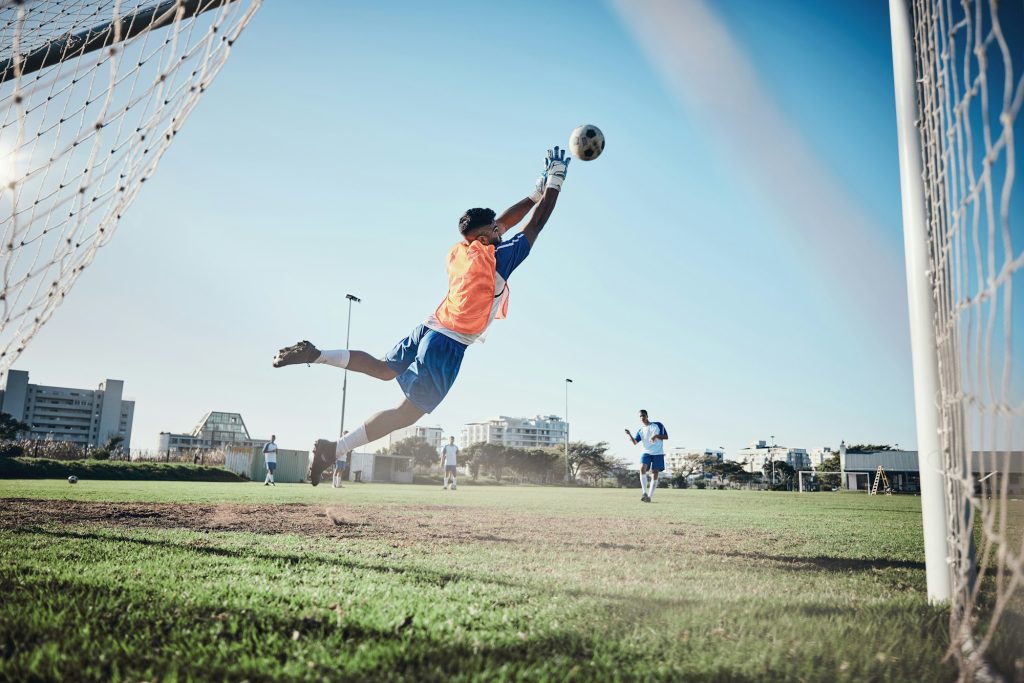 Fitness, goalkeeper or soccer player taking a penalty in a game or training match at a tournament.