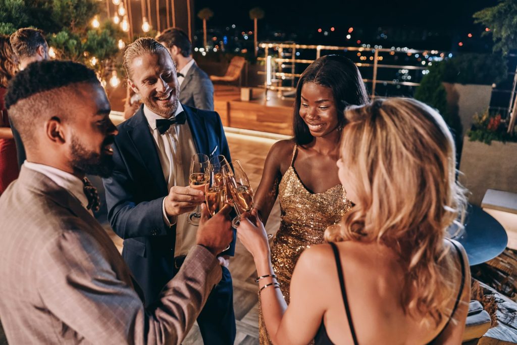 Group of people in formalwear communicating and smiling while spending time on luxury party