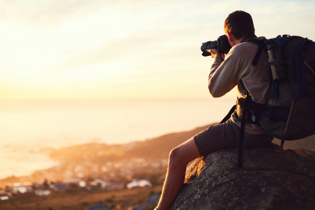 Hike more, worry less. Shot of a young photographer taking a picture from the top of a mountain.