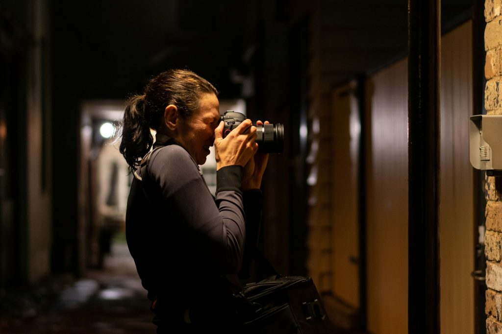 Lady photographer at night taking photos in the city