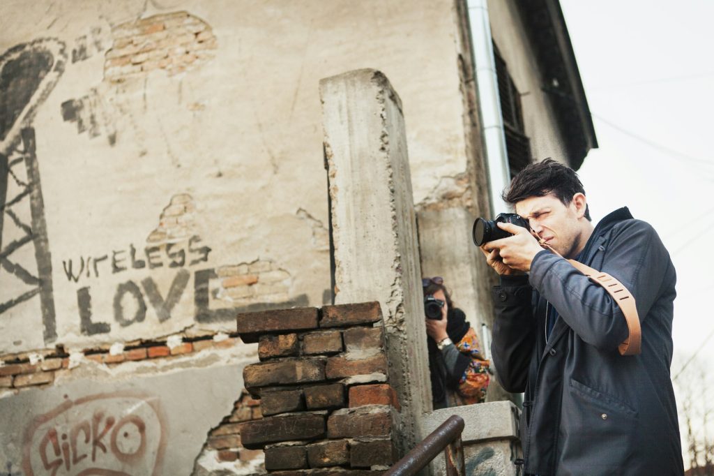 Man and woman photographing at damaged building