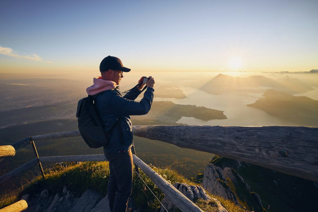 Man photographing landscape at beautiful sunrise