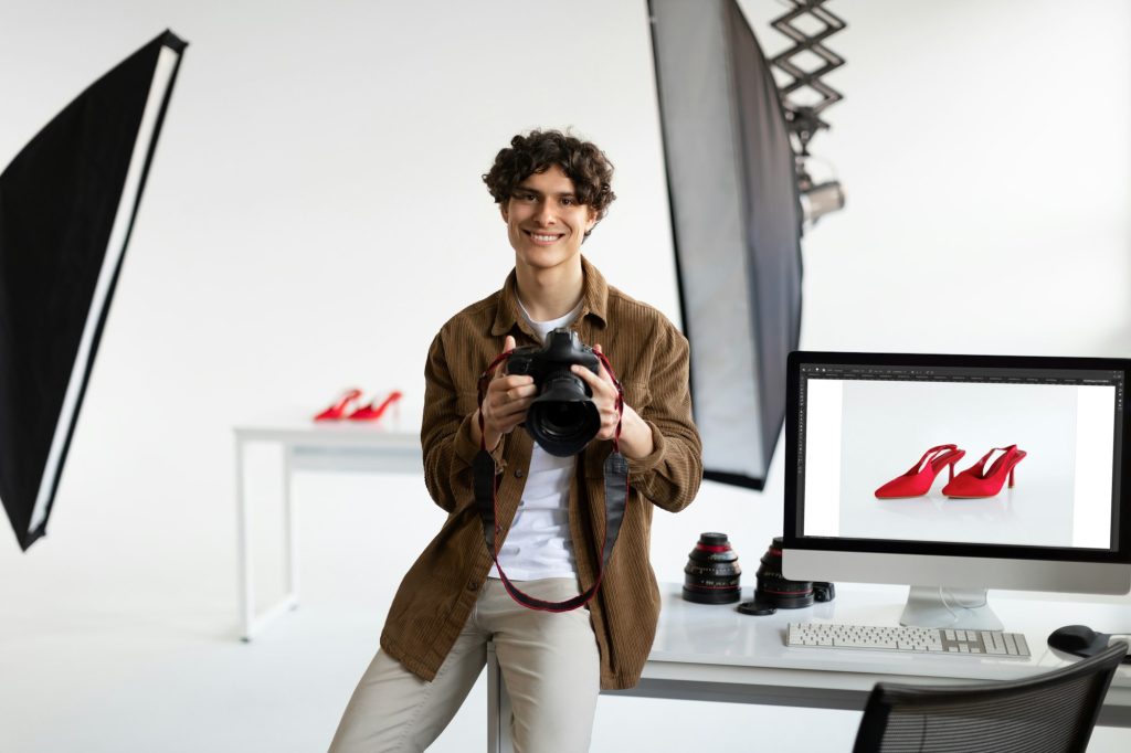 Photographer checking the shot on computer, man working with stylish shoes, enjoying result after