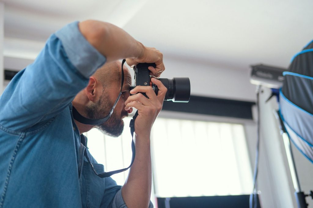 Photographer shooting a model in a studio with a softbox