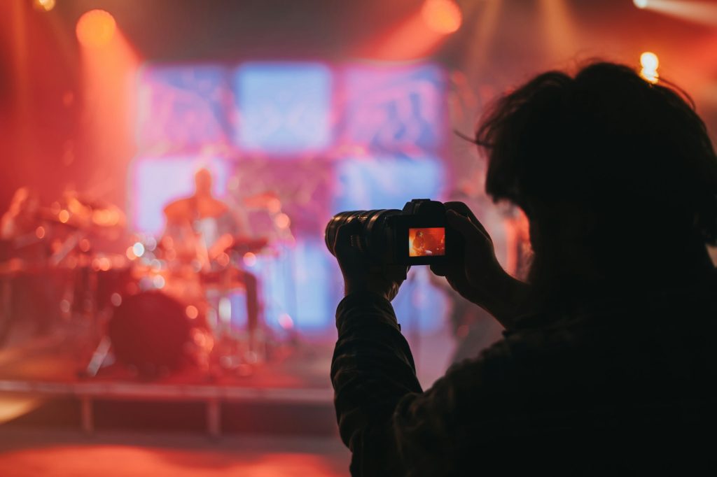 Photographer taking shot of a musician on the stage