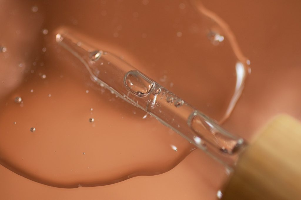 Pipette from dropper in the cosmetics gel.Top view,liquid cosmetic,macro photography.