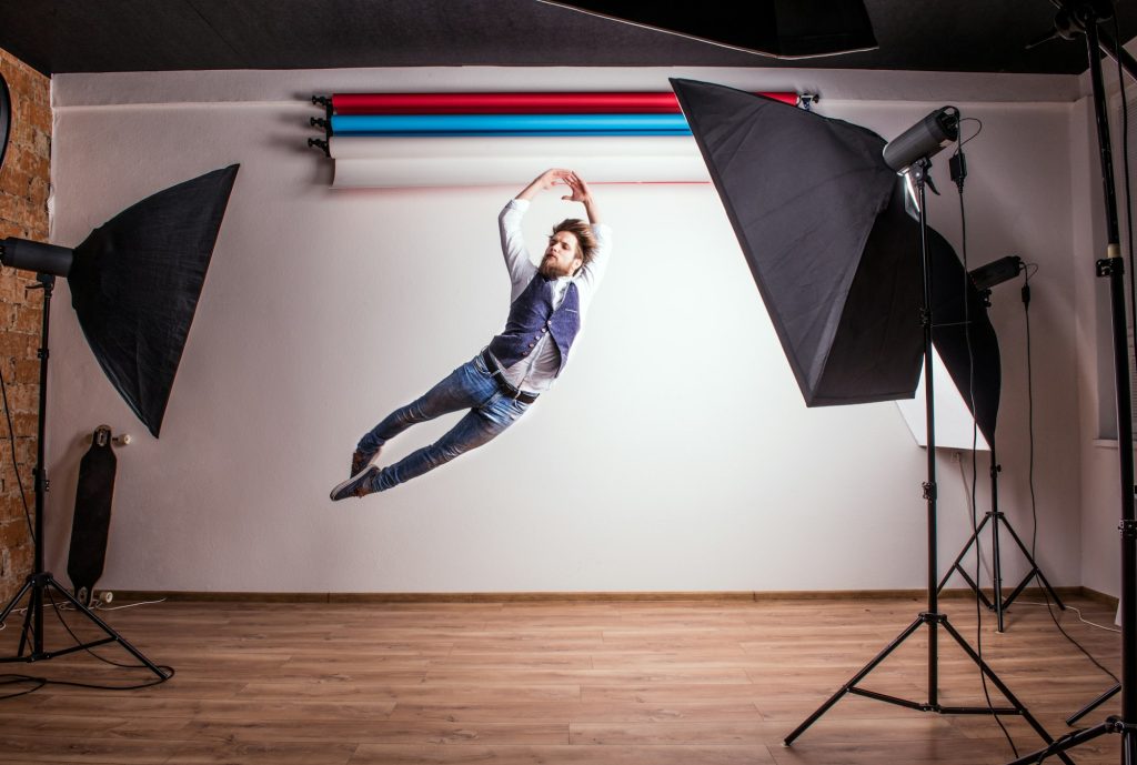 Portrait of a young hipster man in a studio, jumping. Copy space.