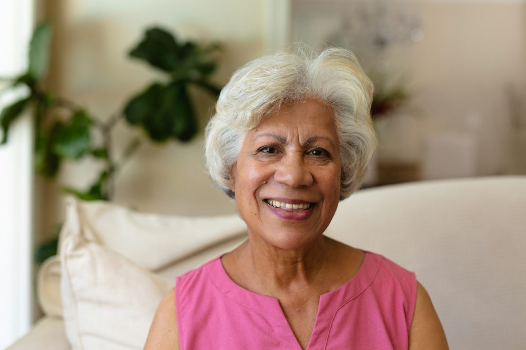 Portrait of african american senior woman smiling sitting on the couch at home