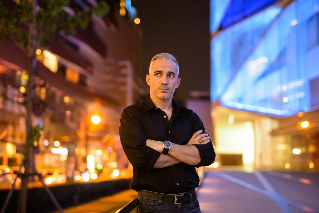 Portrait of attractive man thinking at night on the streets