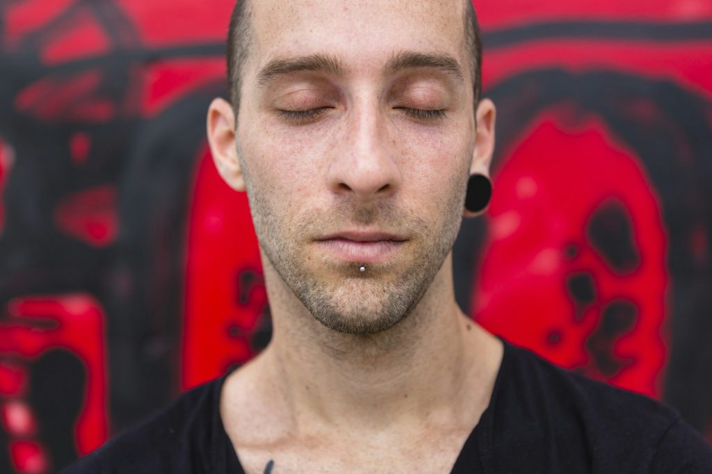 Portrait of pierced man with eyes closed