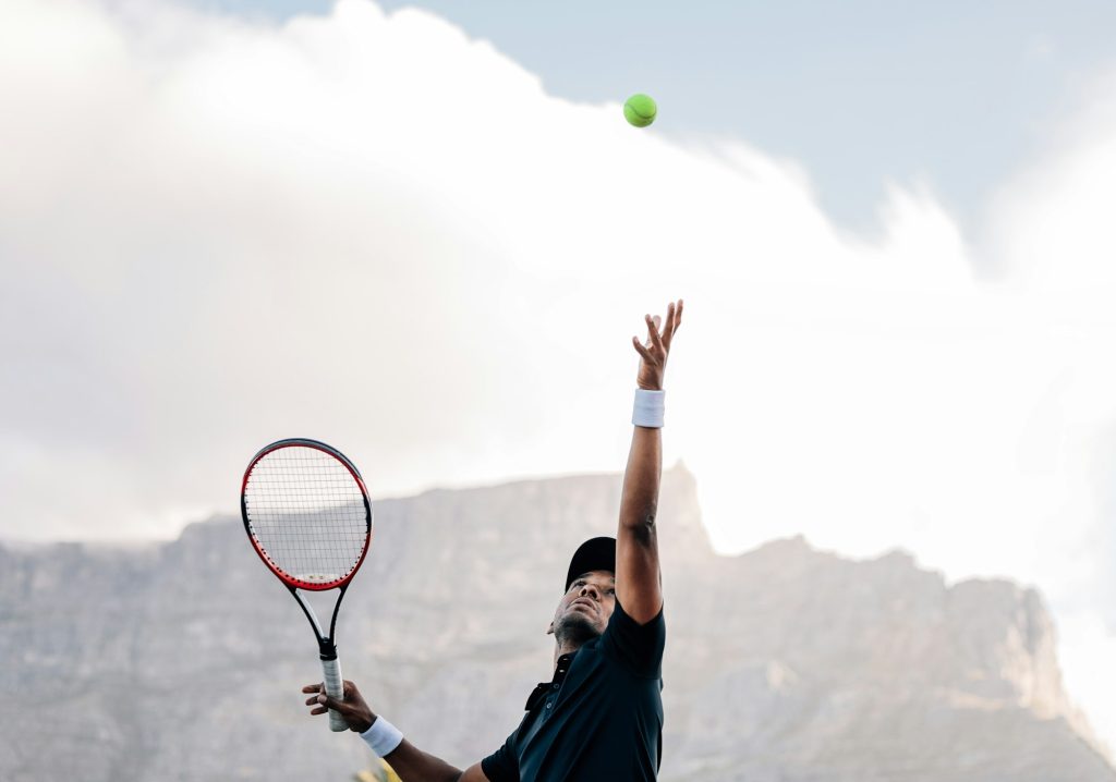 Professional tennis player throwing ball in the air before serve