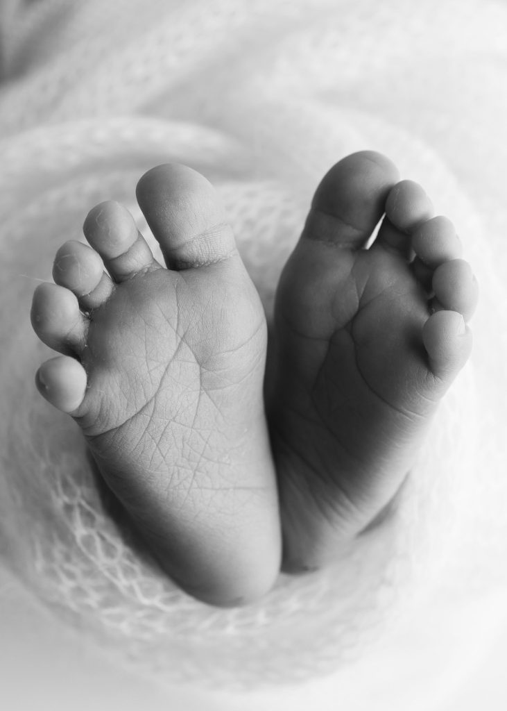 Soft feet of a new born in a wool blanket. Black and white Macro photography.