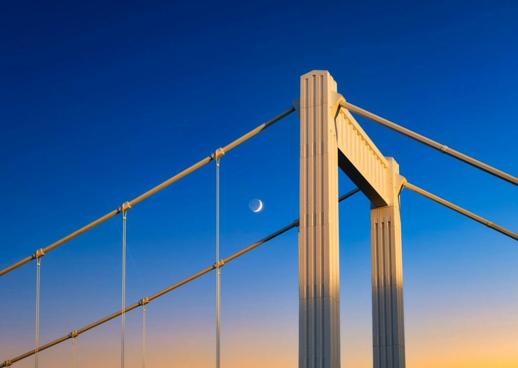 The bridge against the sunset sky. Urban architecture and sky gradient during sunset.