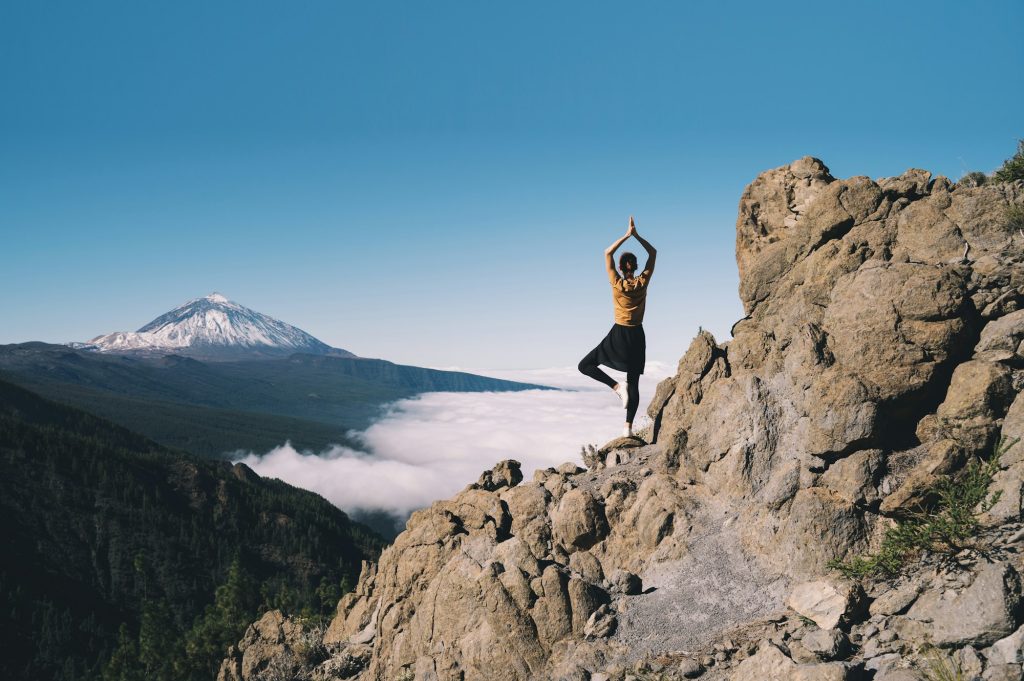Woman doing yoga and meditating on background of natural landscape